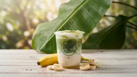 Banana matcha in a Bagel or Nothing cup with matcha powder dusting down
